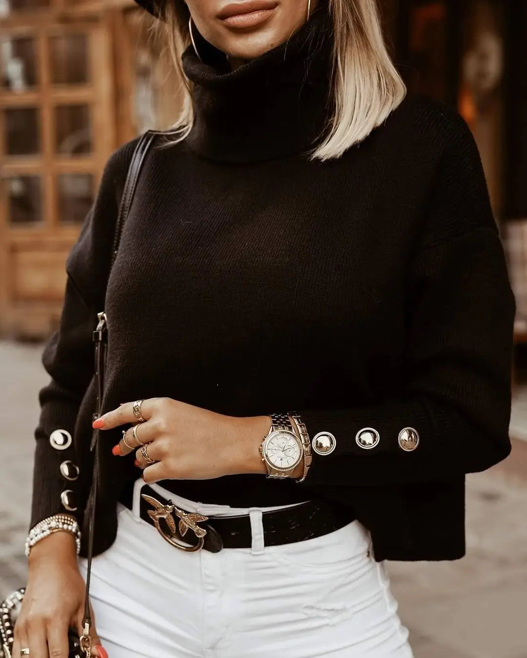 Women's high neck knit sweater with button details on the sleeves