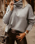 Women's high neck knit sweater with button details on the sleeves